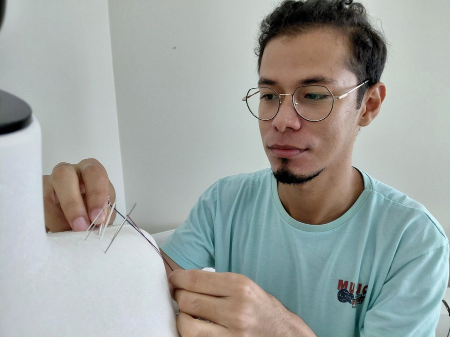 Jhon Jairo Plata Cuenta working on a garment